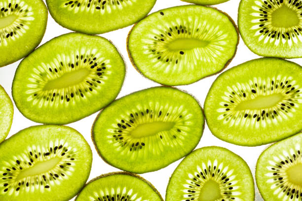 istock Sliced kiwi slices backlit isolated on white. Fruit background, top view 1327868917