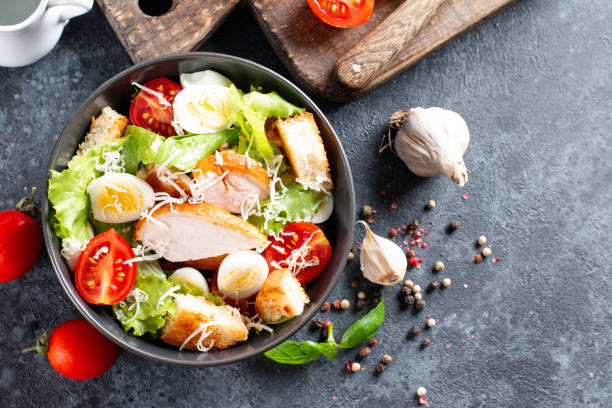istock Caesar Salad with smoked chicken and parmesan on dark background. Top view, copy space. 1327868975