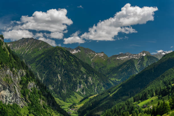 istock Summer valley with Grossarler Ache small river and blue cloudy sky 1327870253