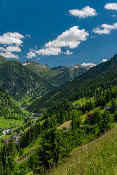 istock Summer valley with Grossarler Ache small river and blue cloudy sky 1327870279
