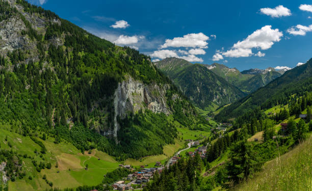 istock Summer valley with Grossarler Ache small river and blue cloudy sky 1327870280