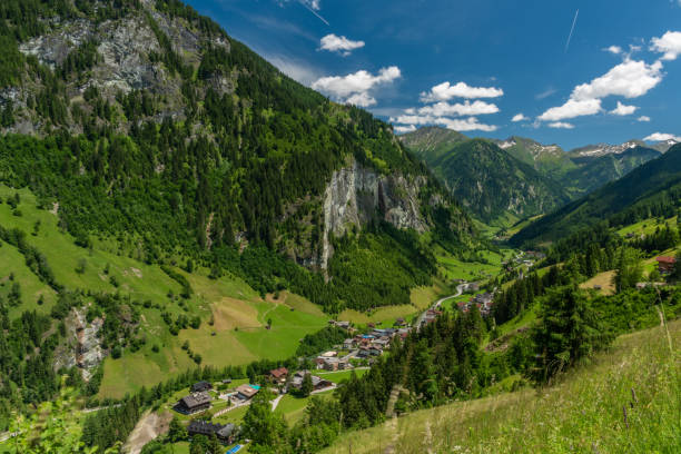 istock Summer valley with Grossarler Ache small river and blue cloudy sky 1327870282