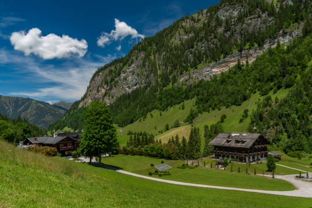 istock Summer valley with Grossarler Ache small river and blue cloudy sky 1327870294