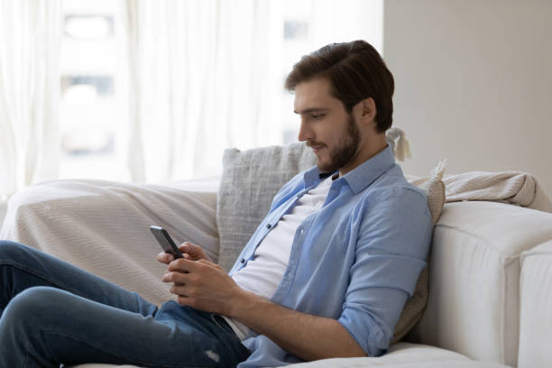 istock Focused engaged millennial young guy with mobile phone 1327874214