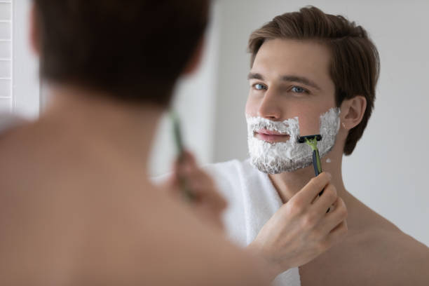 ragazzo giovane attraente positivo con schiuma di gel sulla faccia inferiore - shorn foto e immagini stock