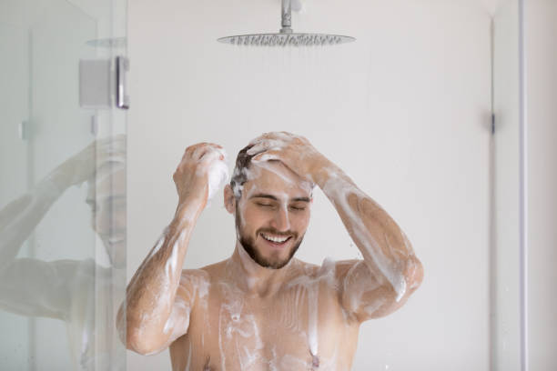istock Happy attractive muscular guy taking shower, washing head 1327874253