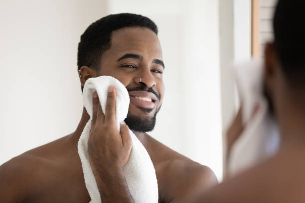 happy handsome african american guy drying face with white towel - stubble imagens e fotografias de stock