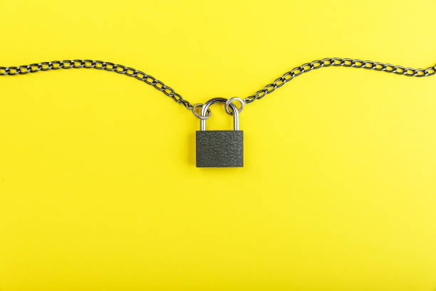 istock locked padlock and chain on yellow background 1327874857