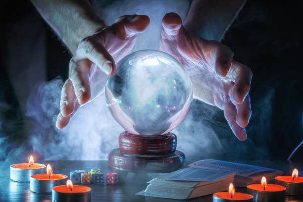 istock Magician or fortune teller is predicting future with crystal sphere. 1327876857