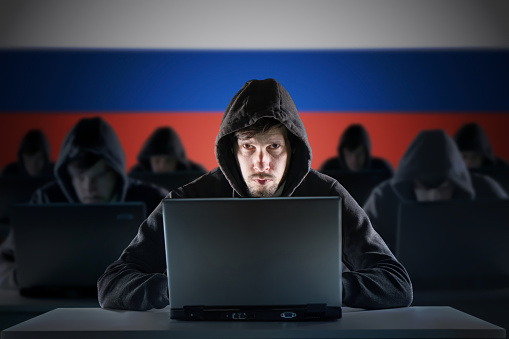 Muchos hackers rusos en la granja de trolls. Concepto de ciberdelincuencia y seguridad. Bandera de Rusia en el fondo. photo