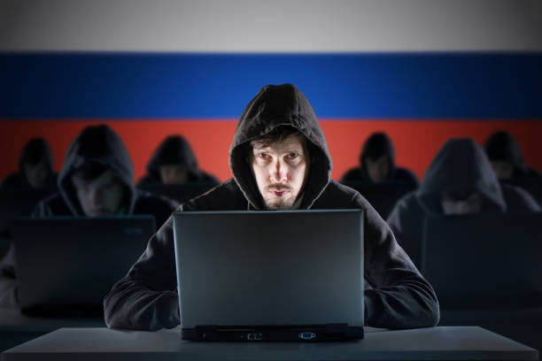 Many russian hackers in troll farm. Cyber crime and security concept. Russia flag in background. stock photo