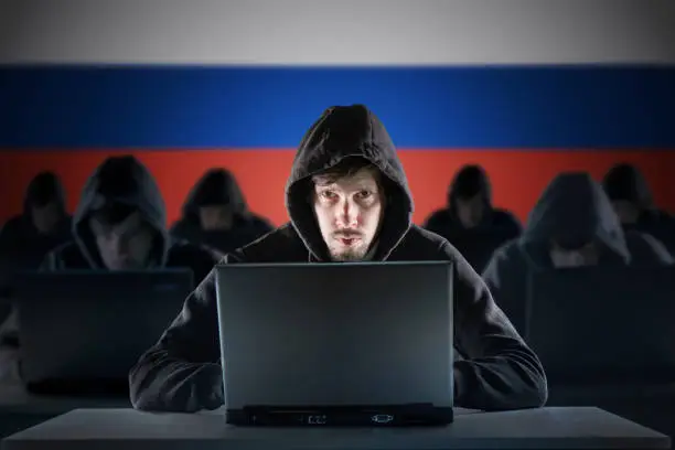 Photo of Many russian hackers in troll farm. Cyber crime and security concept. Russia flag in background.