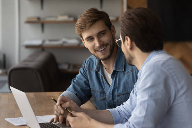 istock Happy two young male colleagues working on online project. 1327880430