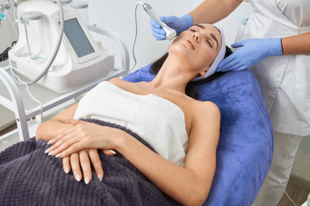 istock Professional cosmetologist is doing procedures for client in light cabinet 1327882433
