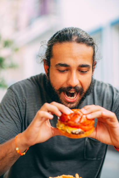 istock Hungry Man Holding Hamburger 1327886952