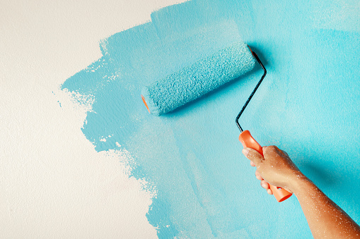 Roller Brush Painting, Worker painting on surface wall  Painting apartment, renovating with blue color paint.