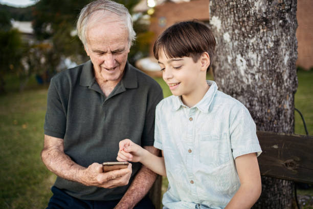 istock Grandson teaching his grandfather how to use smartphone. 1327896592