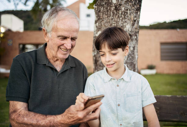 istock Grandson teaching his grandfather how to use smartphone. 1327896697