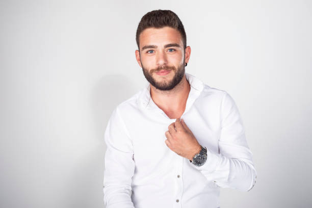 istock Young man in a white shirt poses against a white background. 1327896756