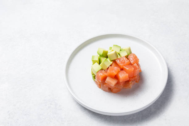 istock Salmon avocado tartare on white stone table background. 1327897950