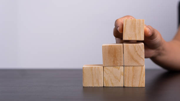 istock A woman holding an empty wooden block on a table where messages can be placed 1327903229