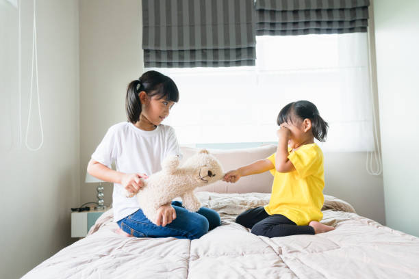 istock two little girl fighting over bear 1327905640