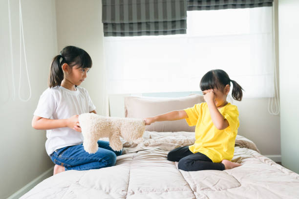 istock two little girl fighting over bear 1327905641
