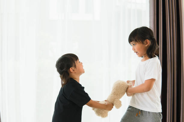 istock two little girl fighting over bear 1327905856