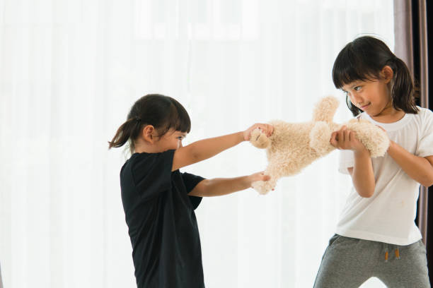 istock two little girl fighting over bear 1327905857