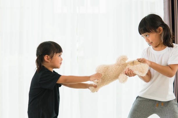istock two little girl fighting over bear 1327905859