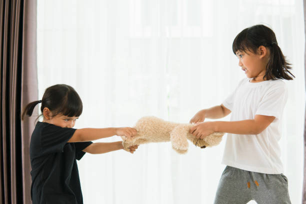 two little girl fighting over bear