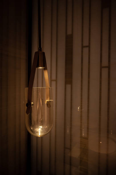 istock Glass LED lamp with leather belt holder hangs from ceiling and reflects in mirror wall. Minimalistic loft interior of real estate house or mansion. Beautiful modern design 1327910308