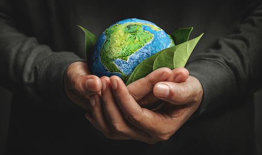 World Earth Day Concept. Green Energy, Renewable and Sustainable Resources. Environmental and Ecology Care. Hand Embracing Green Leaf and Handmade Globe