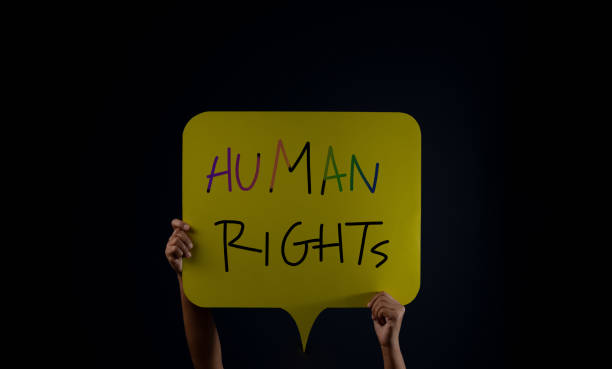 istock Speech to Freedom. Protest , Mob or Expression Concept. Person Raised Up a Human Rights text in the Dark 1327919664