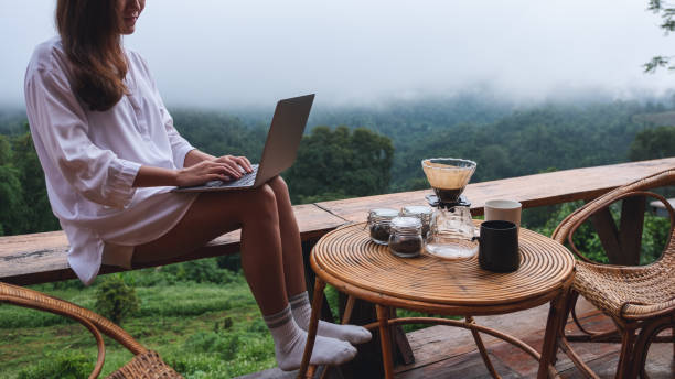 istock a woman using and working on laptop computer while sitting on balcony with a beautiful nature view on foggy day 1327924084