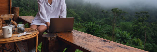 istock a woman using and working on laptop computer while sitting on balcony with a beautiful nature view on foggy day 1327924173