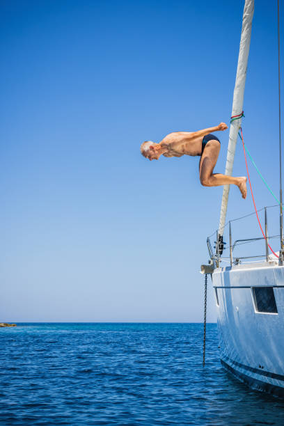 istock Man jumping in sea from sailboat 1327934802