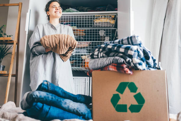 Recycle clothes concept. Young woman with recycling box full clothes. Recycle clothes concept. Young woman with recycling box full clothes. arrangement stock pictures, royalty-free photos & images