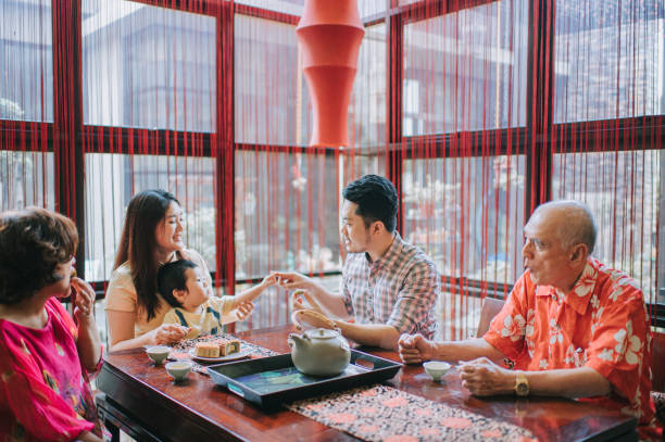 istock Chinese father playing with son during  multi generation enjoying traditional mid-autumn mooncake and chinese tea at home during afternoon tea gathering 1327937740