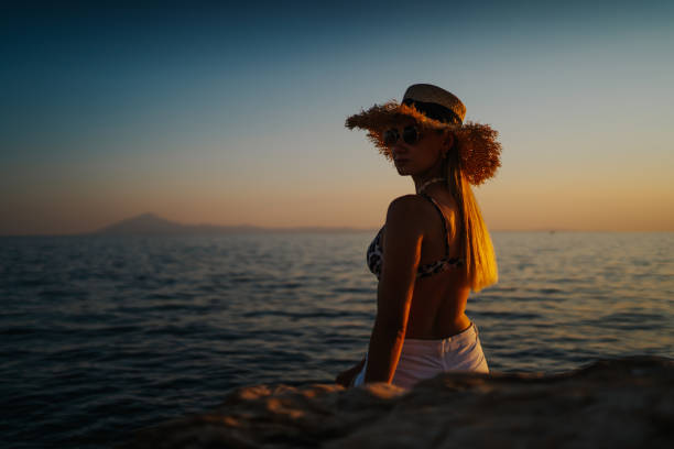 istock Young woman with a hat sunbathing on the cliff 1327938732