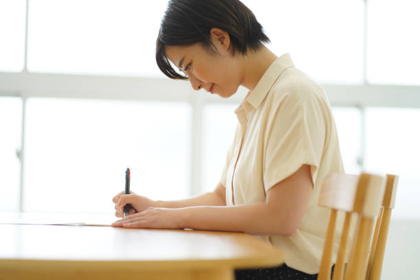 a woman practicing ballpoint pen writing - writing letter correspondence women imagens e fotografias de stock