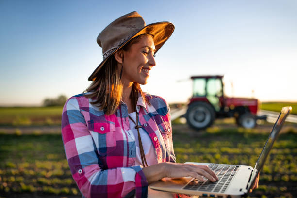 фермер с ноутбуком перед трактором - farmer rural scene laptop computer стоковые фото и изображения