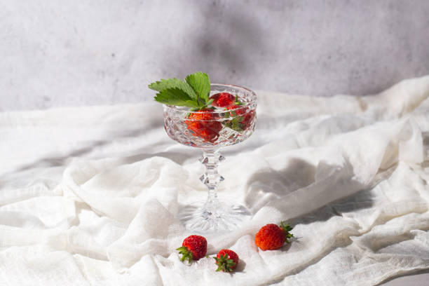 istock Fresh juicy strawberries in a glass on a light fabric background 1327955477