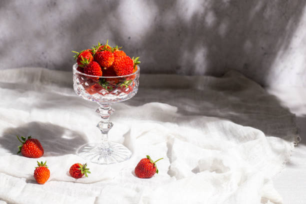 istock Fresh red strawberries in a glass on a table on a concrete background 1327955504