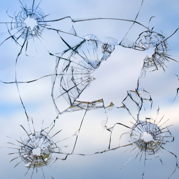 istock Broken window glass on a background of blue sky 1327958172