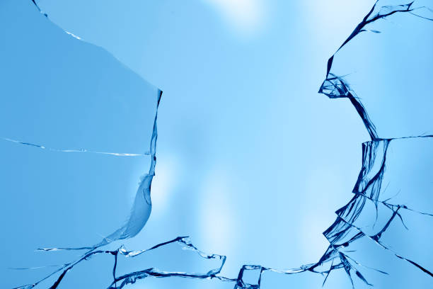 istock Broken window glass on a background of blue sky 1327958181
