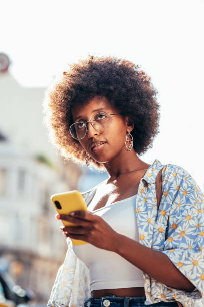 istock african young woman using using her smart phone on the streets 1327959077