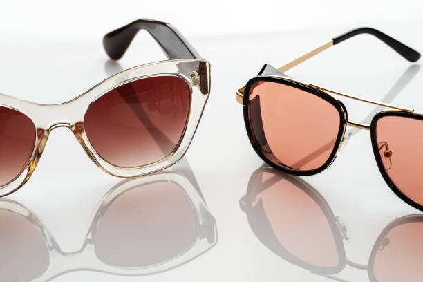 istock Sunglasses on a white reflective surface. Fashionable, stylish accessories. Use it for a vacation or summer concept. 1327959964