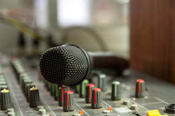 istock Recording studio mixing room with wireless microphones on a mixer control table. 1327961143