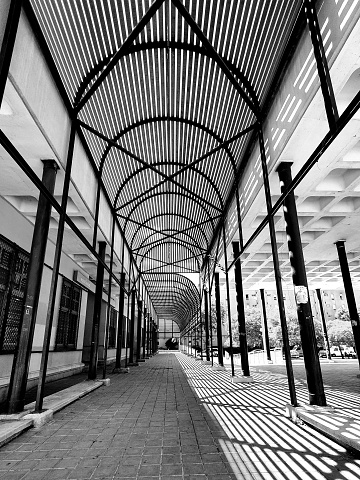 Background image with multiple uses. It's play of diagonal lines contrasting black and white. It shows the structure of a building between light and shadow.
